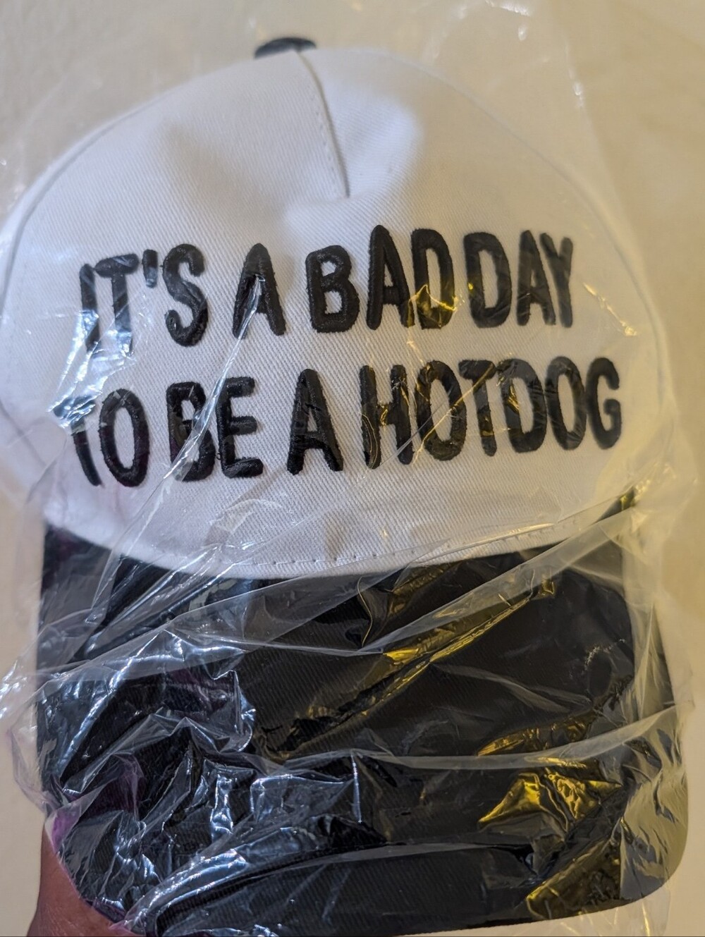 White and Black Cap with 'IT'S A BAD DAY TO BE A HOTDOG' Embroidered Slogan